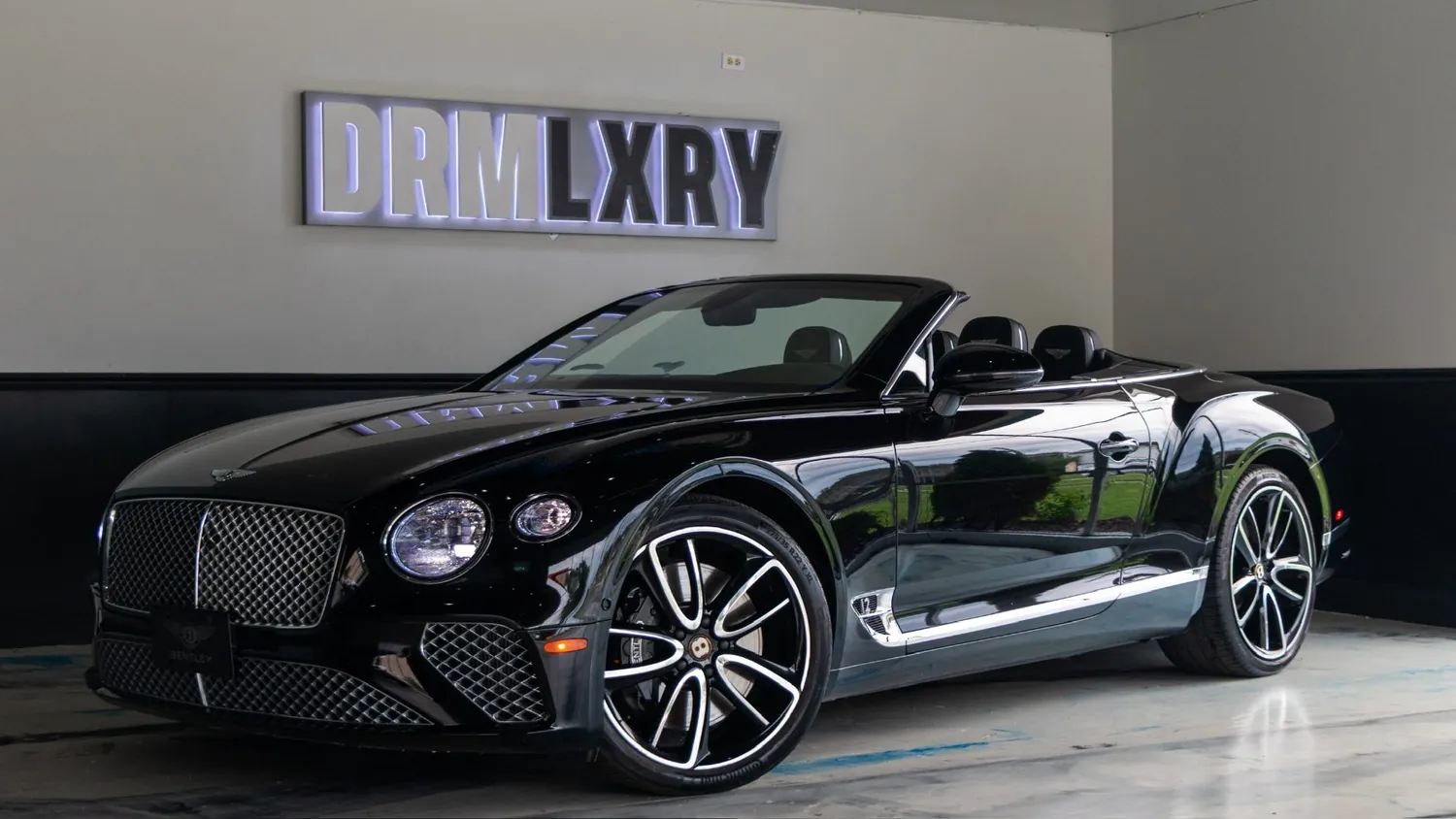 Black Bentley Continental GTC rental in Detroit, front three-quarter view facing left, in the DRMLXRY showroom