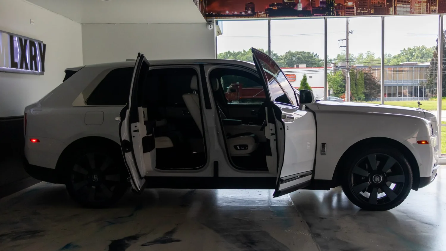White Rolls-Royce Cullinan rental in Detroit, side profile with the coach doors open
