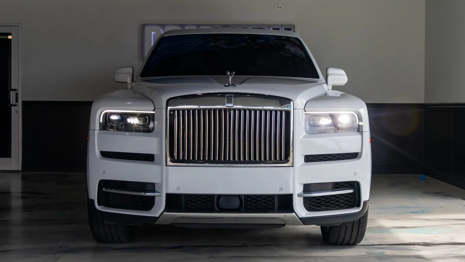 White Rolls-Royce Cullinan rental in Detroit, front view with the grille and headlights
