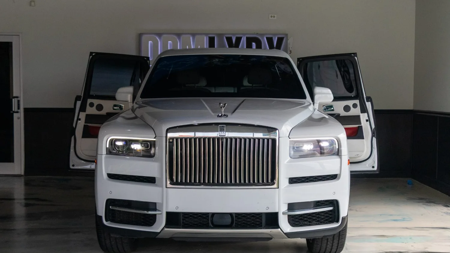 White Rolls-Royce Cullinan rental in Detroit, front view with the doors open