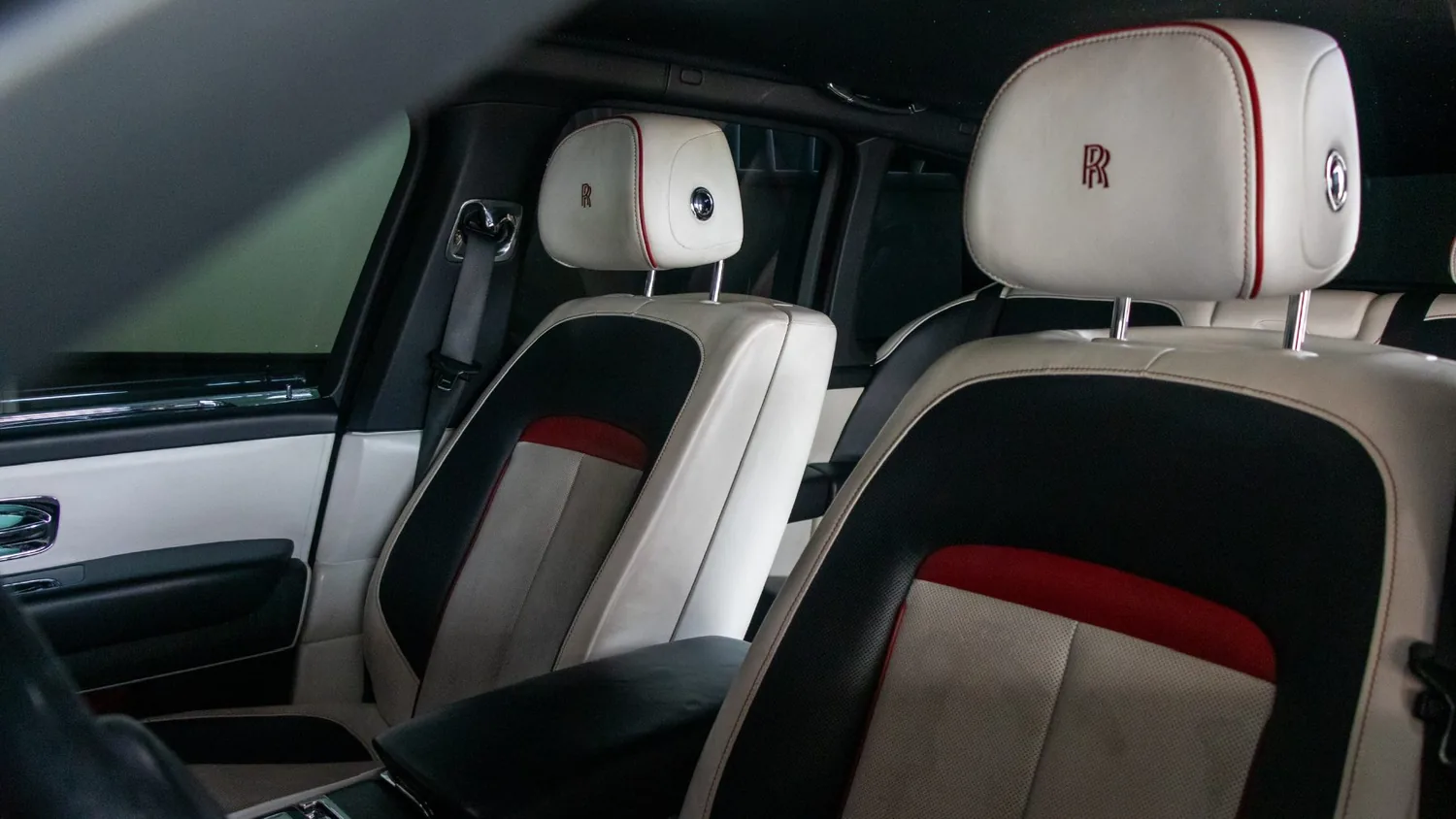 White Rolls-Royce Cullinan rental in Detroit, front seats in white and black leather with red accents