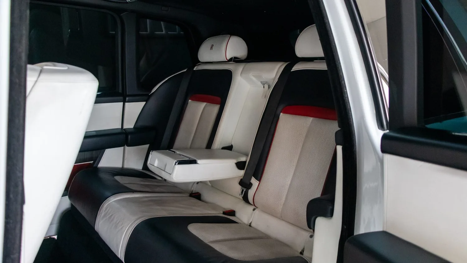 White Rolls-Royce Cullinan rental in Detroit, rear bench seat with the armrest down