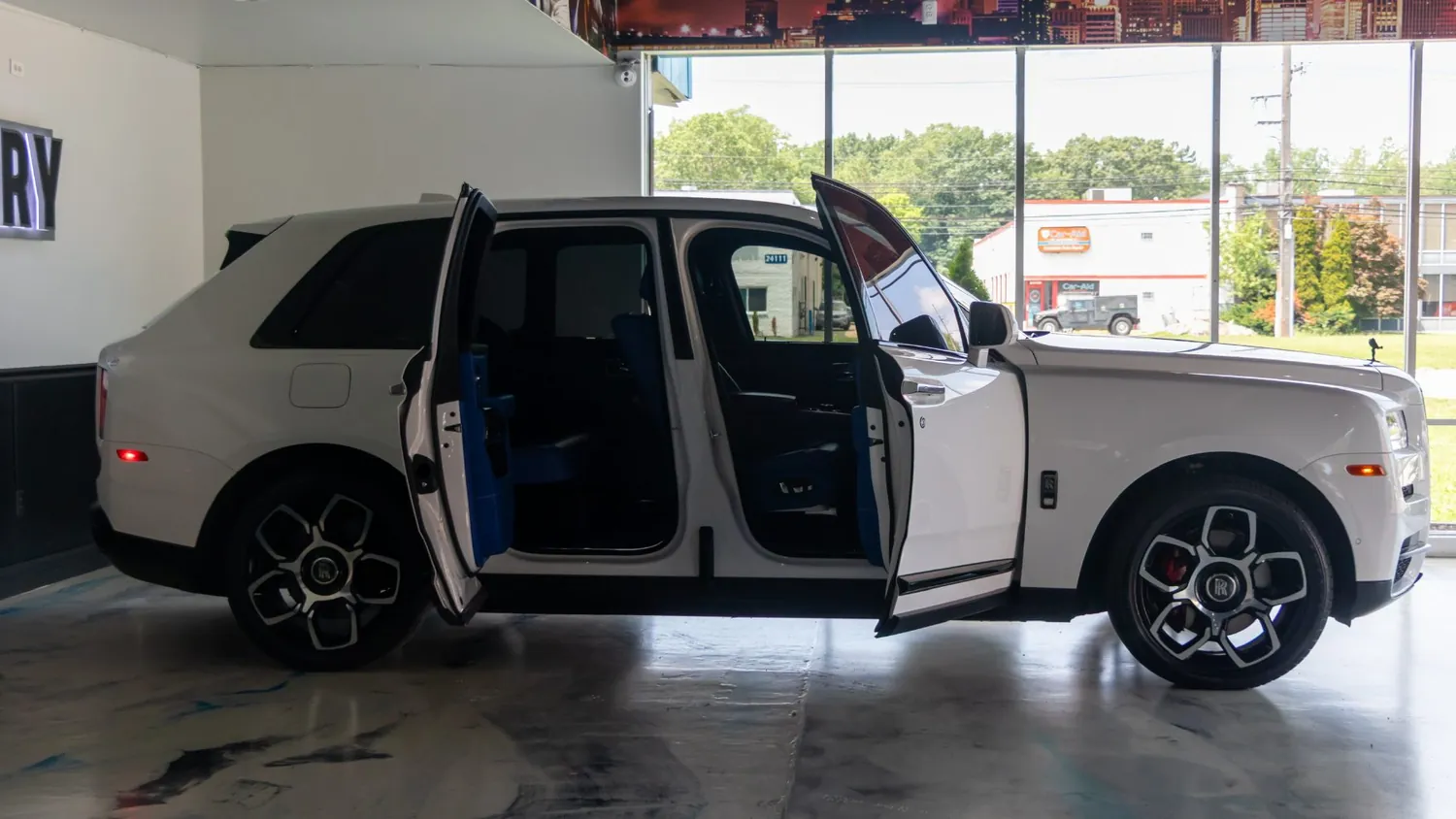 White Rolls-Royce Cullinan rental in Detroit, side profile with the coach doors open