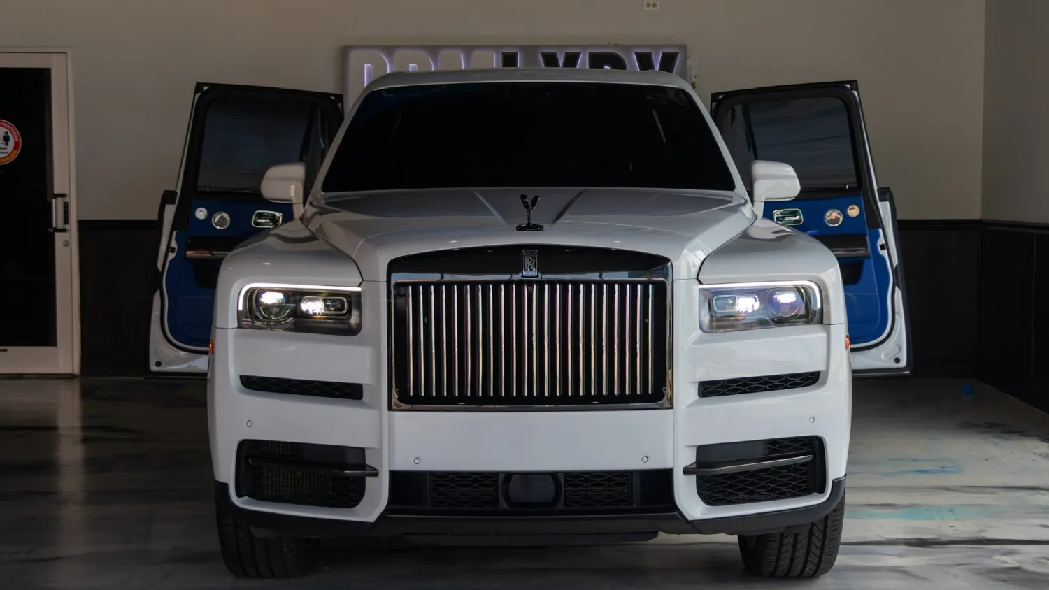 White Rolls-Royce Cullinan rental in Detroit, front view with the doors open