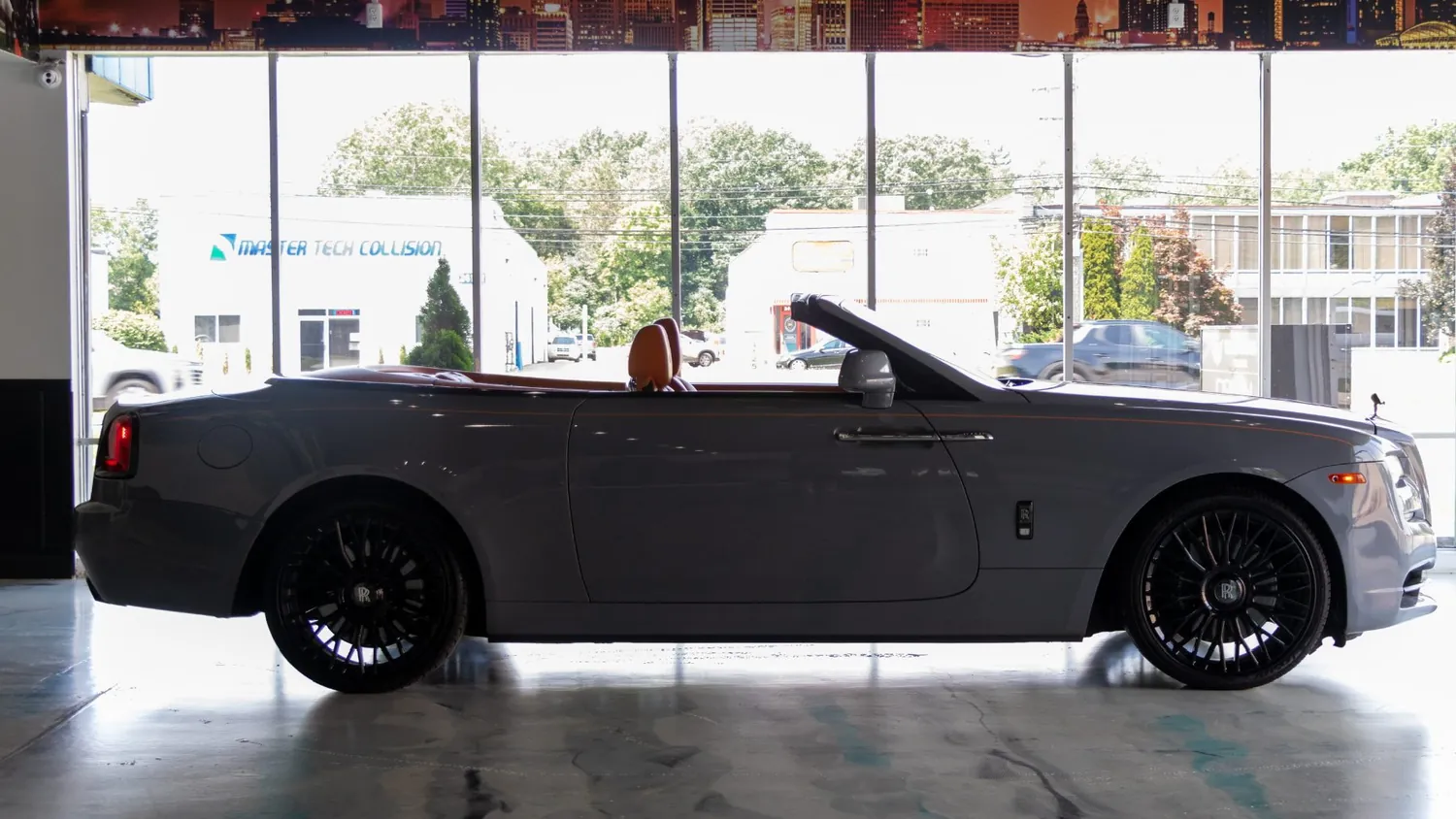 Silver Rolls-Royce Dawn rental in Detroit, side profile with the roof down