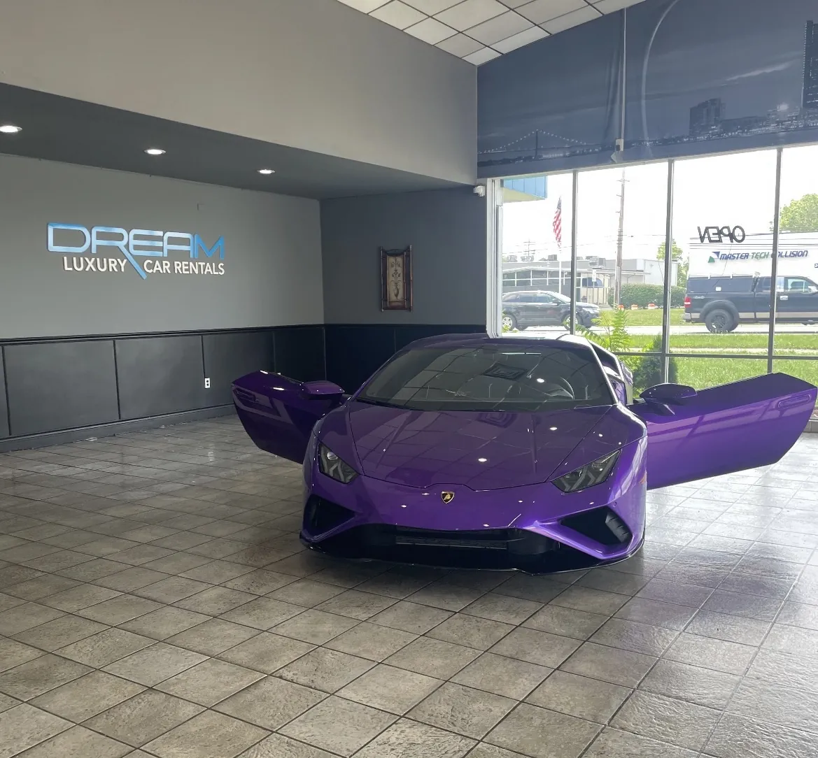 Purple Lamborghini Huracán EVO rental in Detroit, with the doors up in the showroom
