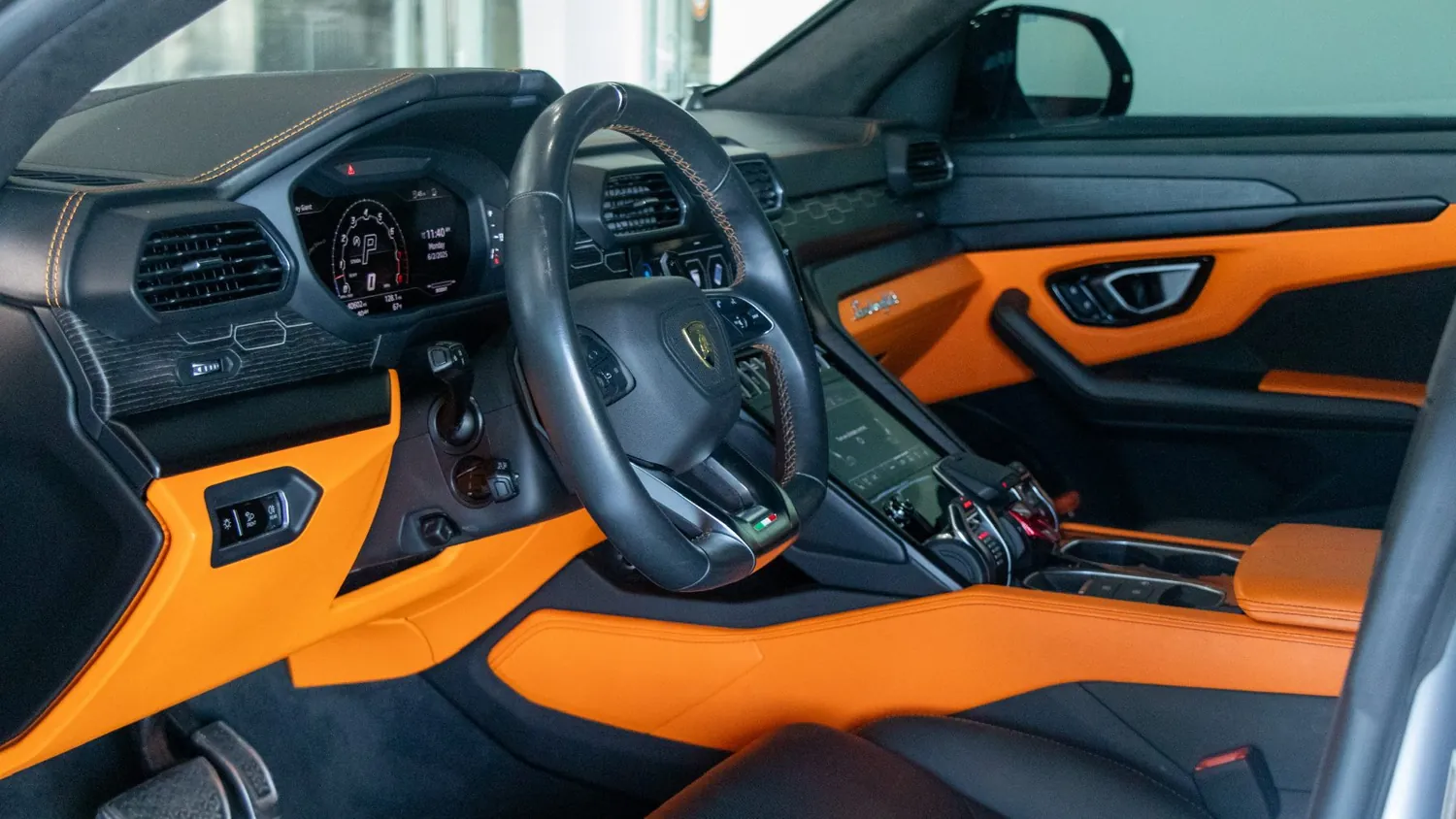 Gray 2022 Lamborghini Urus rental in Detroit, cockpit with orange leather