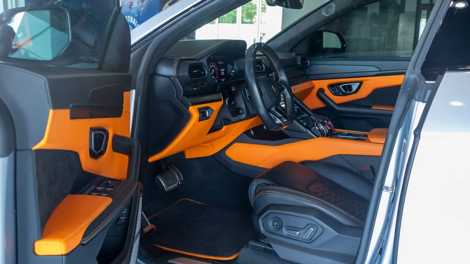 Gray 2022 Lamborghini Urus rental in Detroit, driver door and dashboard