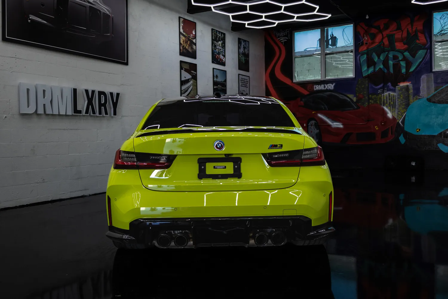 Rear view of the yellow BMW M3 Competition with quad exhaust