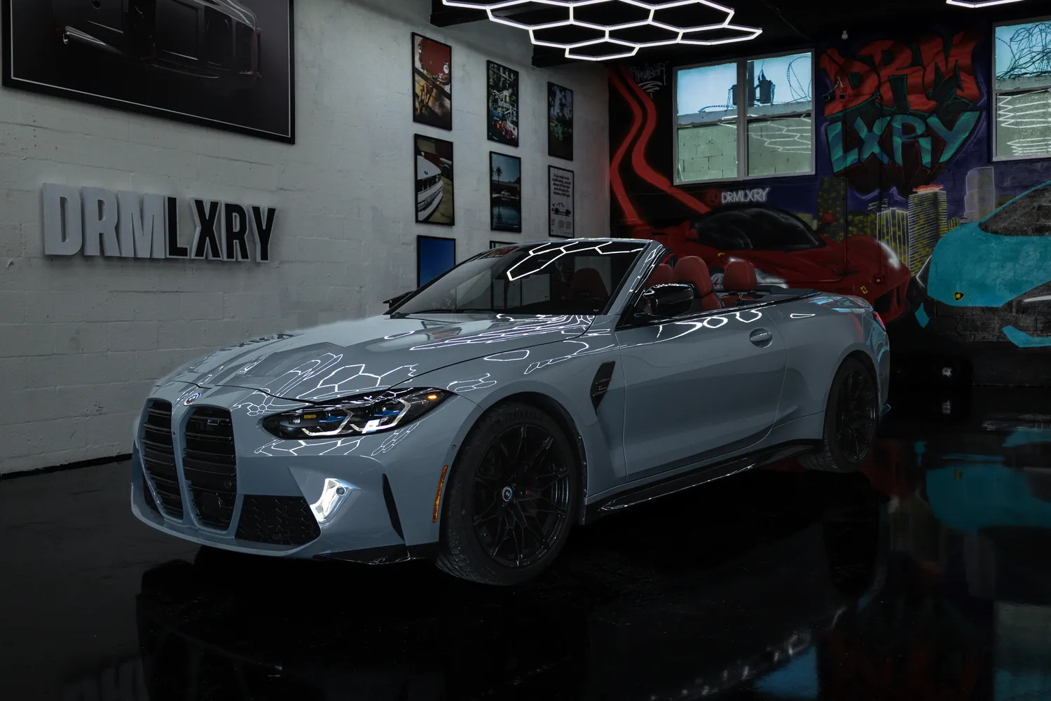 Grey 2023 BMW M4 Competition Convertible, front three-quarter view facing left with the top down, in the DRMLXRY Miami showroom