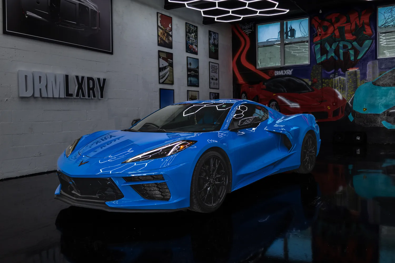 Blue 2024 Chevrolet Corvette Stingray coupe, front three-quarter view facing left, in the DRMLXRY Miami showroom