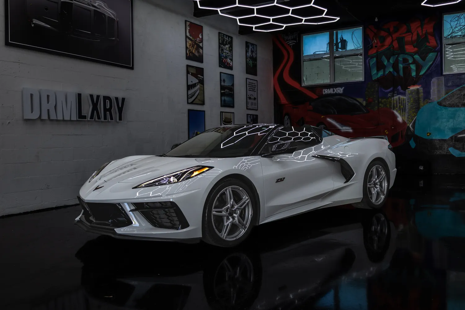 White 2023 Chevrolet Corvette Stingray Convertible, front three-quarter view facing left, in the DRMLXRY Miami showroom