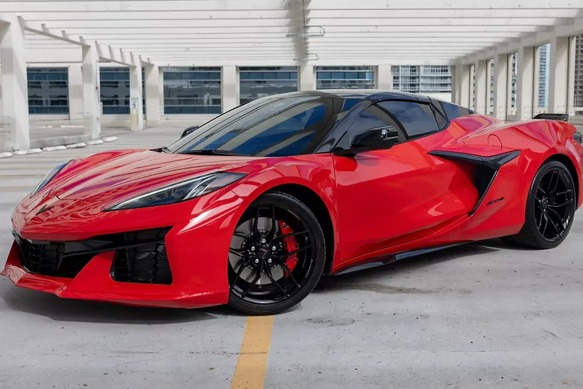 Red 2025 Chevrolet Corvette Z06, front three-quarter view facing left, in a Miami parking deck