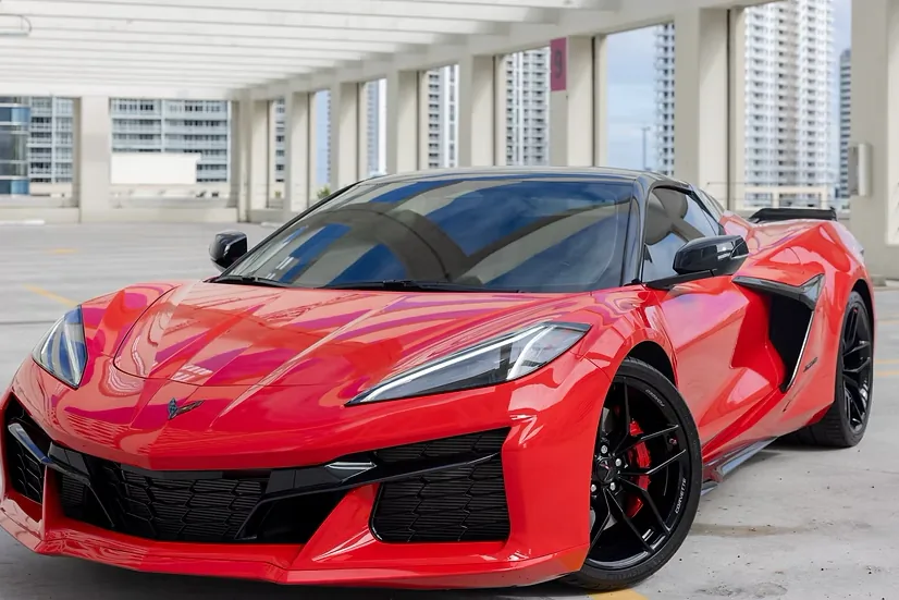 Red Corvette Z06, low front three-quarter view with LED headlights and black wheels