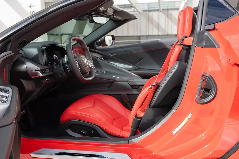 Corvette Z06 with the driver's door open, showing the red interior
