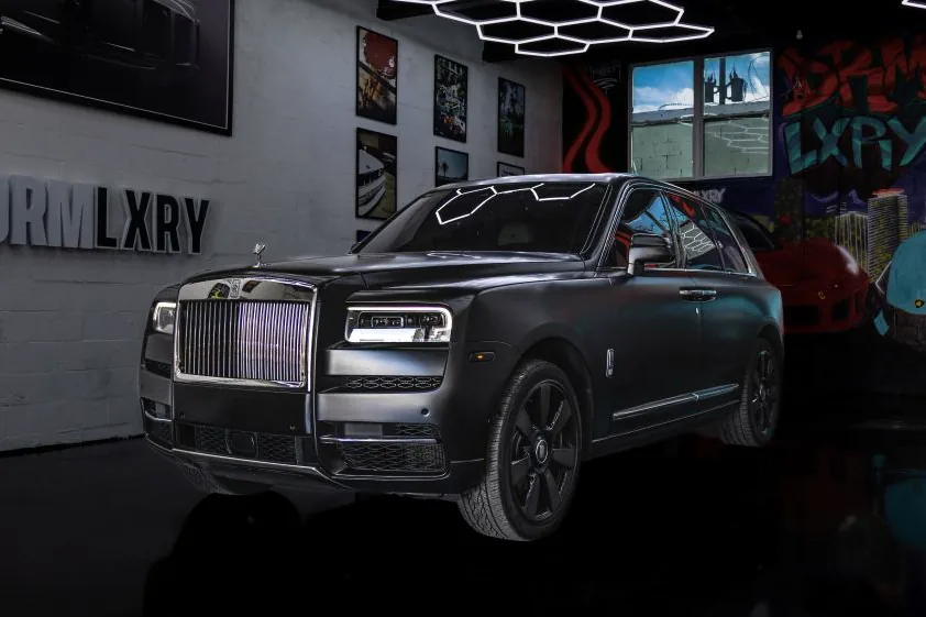 Black 2022 Rolls-Royce Cullinan, front three-quarter view facing left, in the DRMLXRY Miami showroom