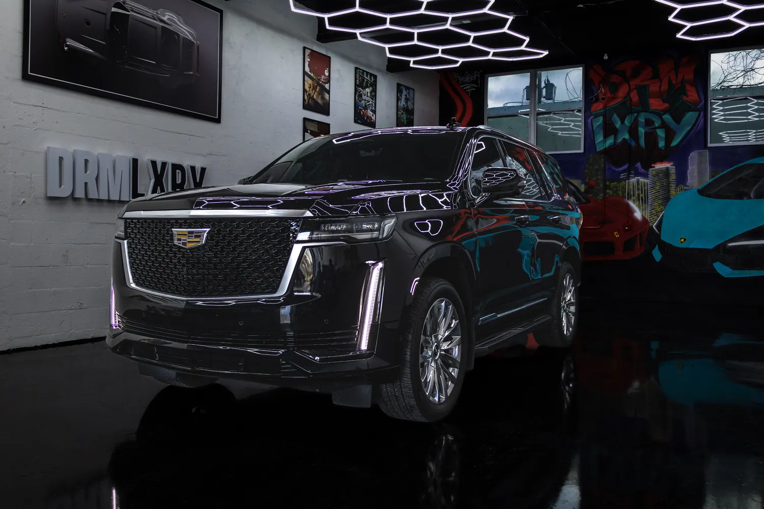 Black 2023 Cadillac Escalade, front three-quarter view facing left, in the DRMLXRY Miami showroom