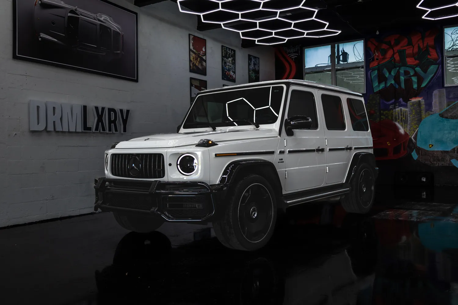 White 2023 Mercedes-AMG G63 G-Wagon, front three-quarter view facing left, in the DRMLXRY Miami showroom