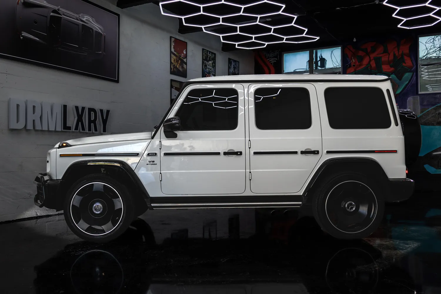 White Mercedes-AMG G63 from the side, showing its upright doors and exposed hinges