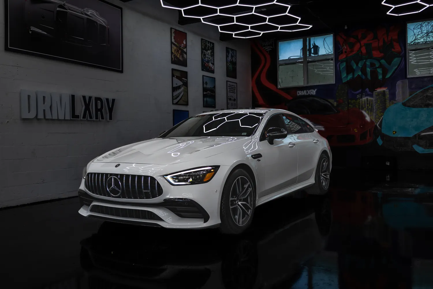 White 2021 Mercedes-AMG GT53, front three-quarter view facing left, in the DRMLXRY Miami showroom