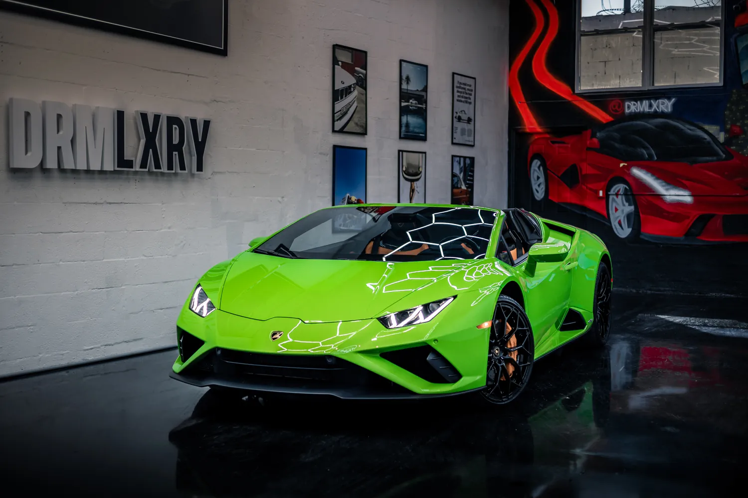 Green 2023 Lamborghini Huracán EVO Spyder, front three-quarter view facing left with the top down, in the DRMLXRY Miami showroom