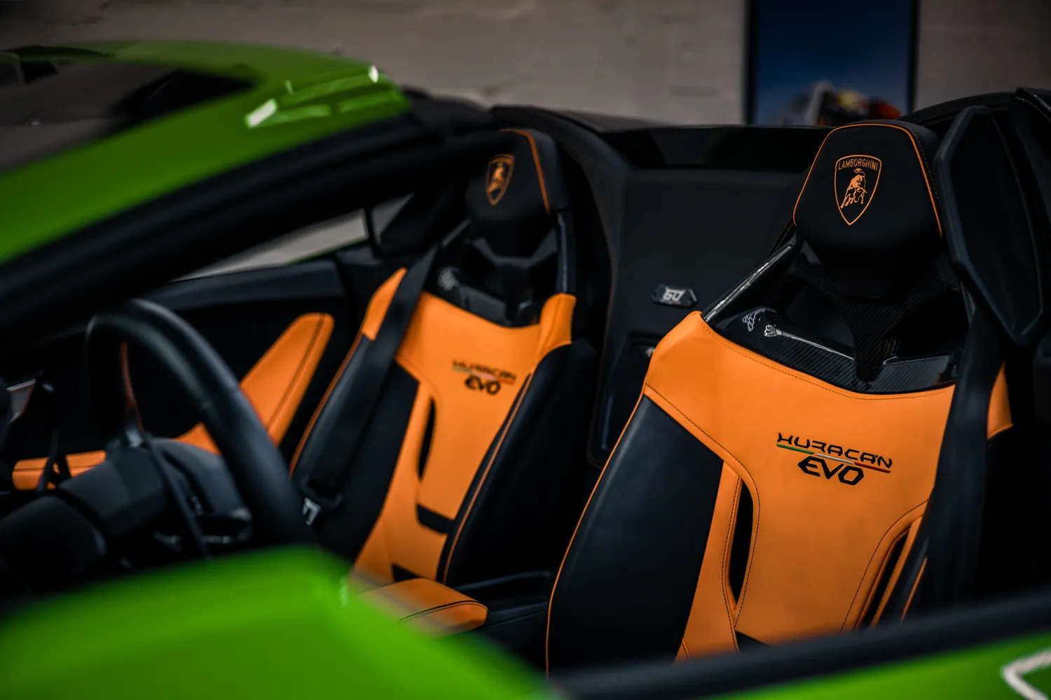 Orange and black Lamborghini sport seats with embroidered Huracán EVO logo