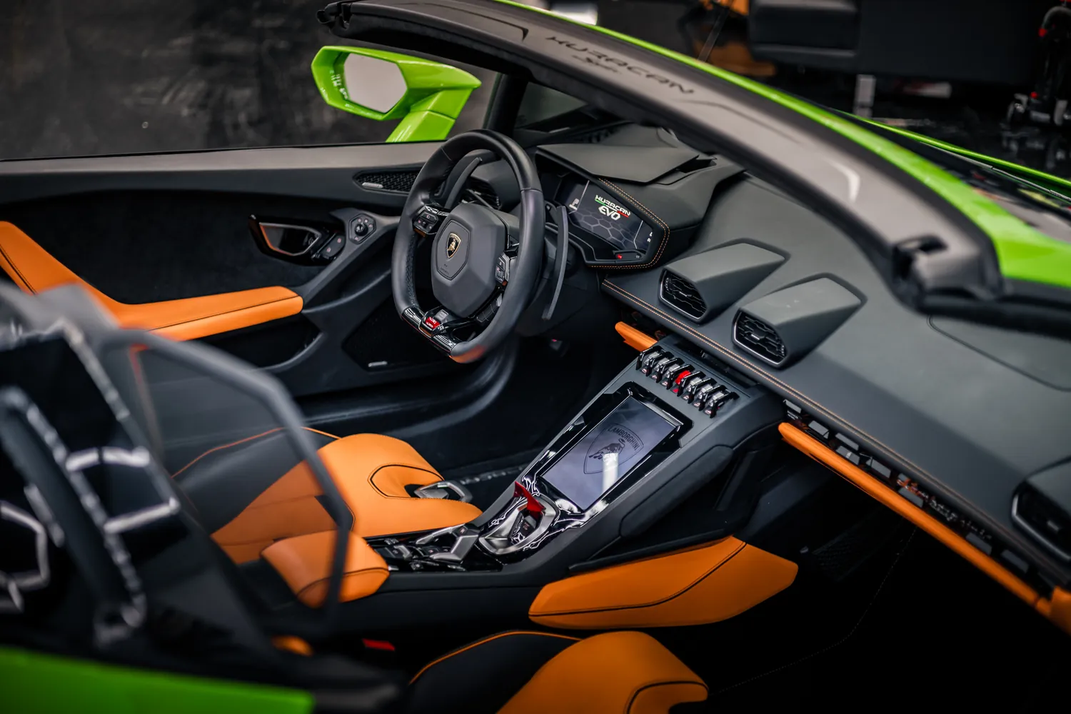 Orange and black cabin of the green Lamborghini Huracán EVO Spyder