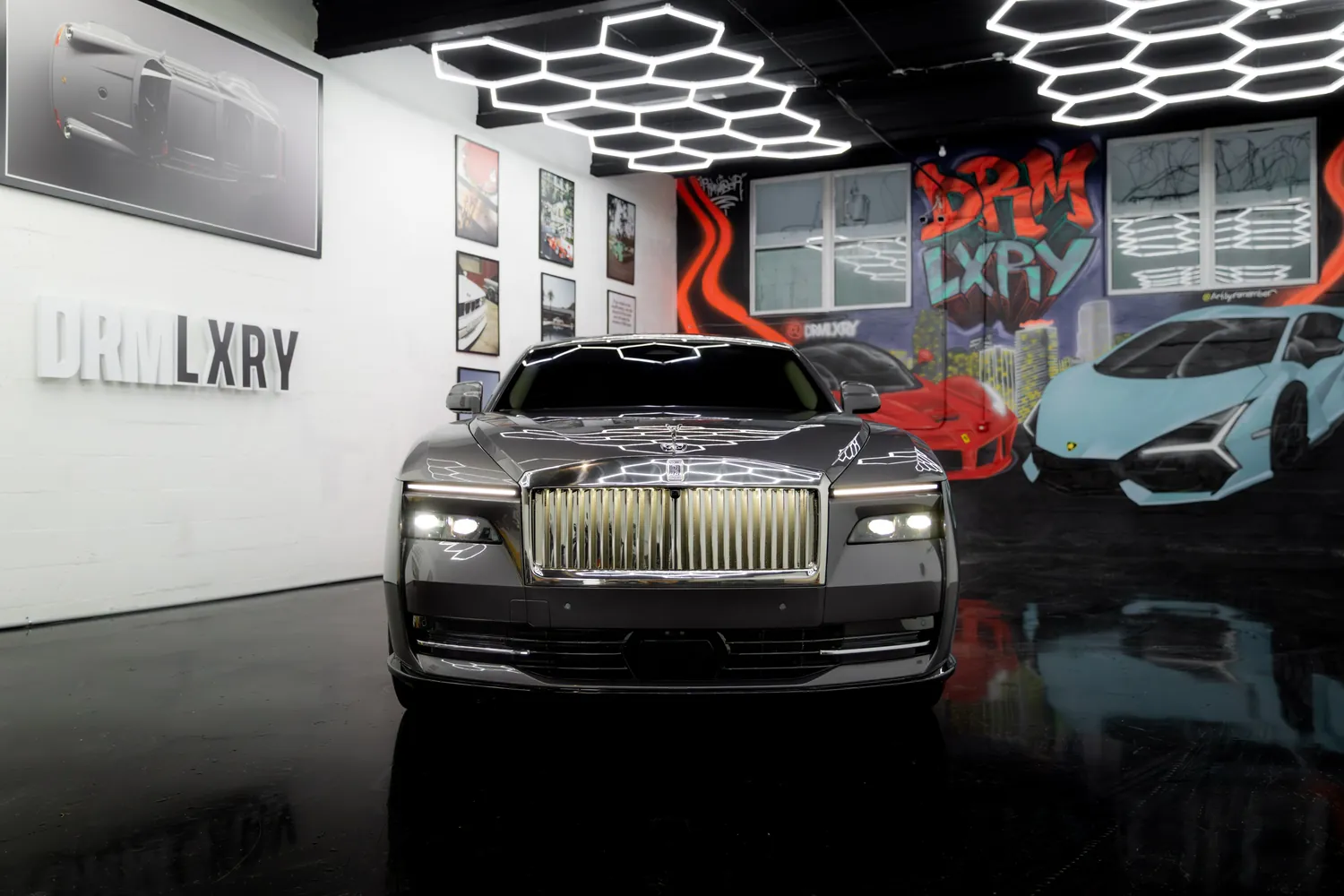 Front view of the grey Rolls-Royce Spectre with its illuminated grille