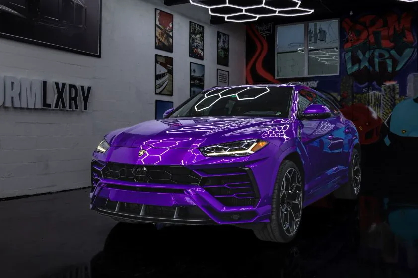 Purple 2021 Lamborghini Urus, front three-quarter view facing left, in the DRMLXRY Miami showroom