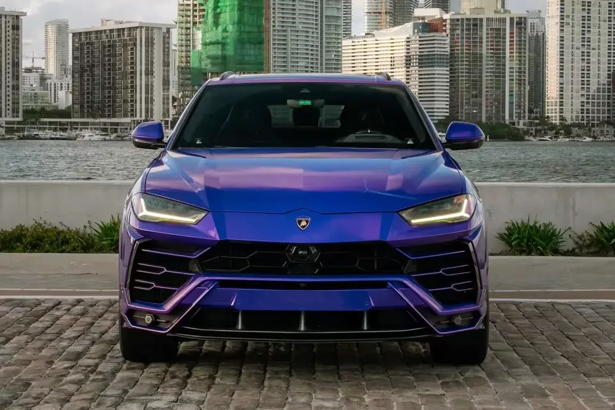 Purple Lamborghini Urus in front of the Miami skyline