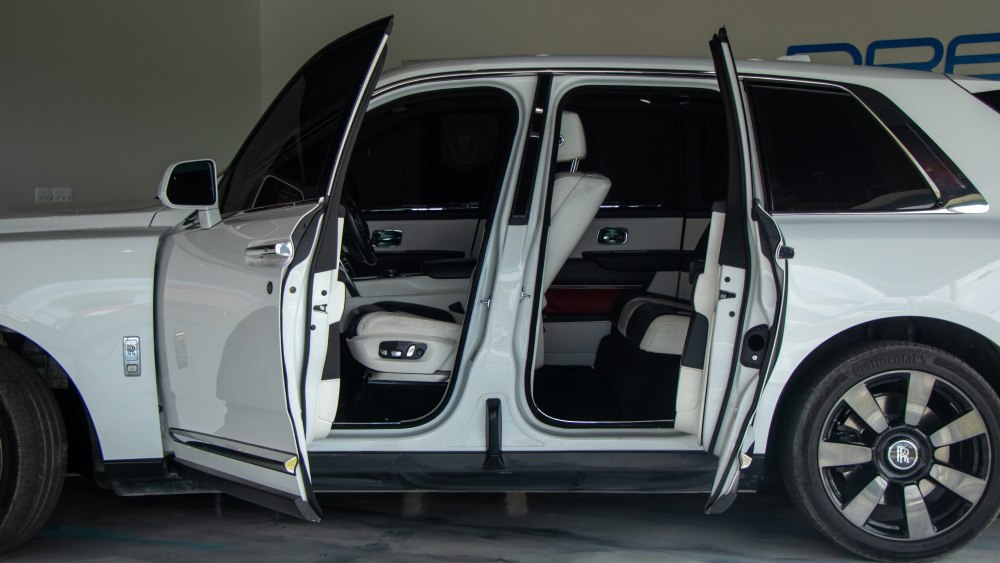 Luxury Rolls-Royce Cullinan rental with the door wide open, showcasing the premium leather interior